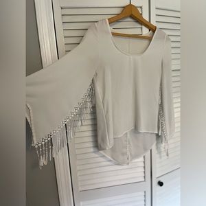 White blouse with flowing sleeves with tassels